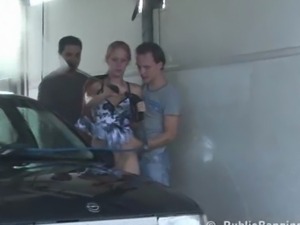 Extreme public sex at a car wash with two guys fucking a pretty girl