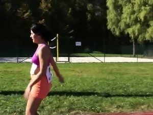 This horny brunette is out on the track field getting wet at